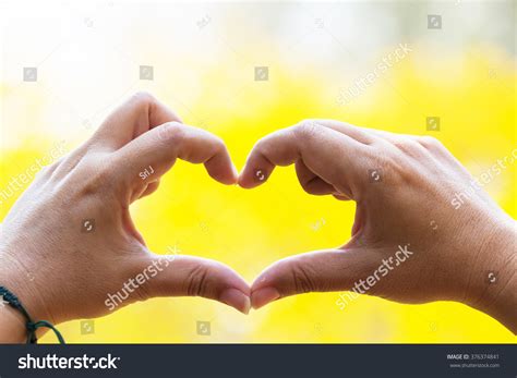hands hart shape yellow background stock photo edit