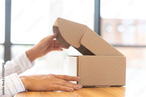 lady opening box   parcel close  stock photo adobe stock