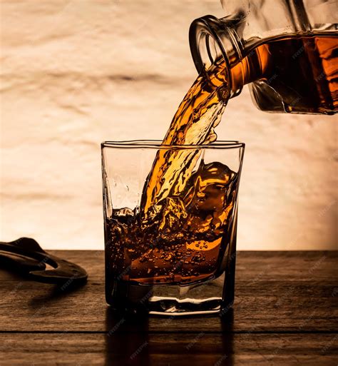 Pouring whisky into a fancy crystal glass. | Premium Photo