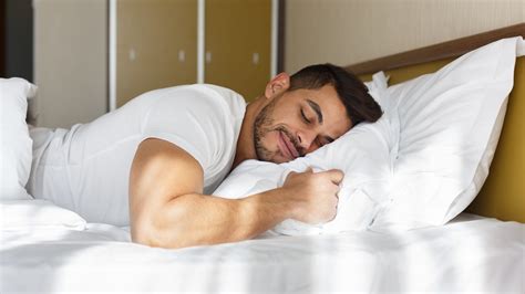 Young man peacefully sleeping in his bed – International Institute of Sleep