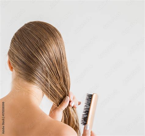 woman  comb brushing  wet blonde hair  shower   gray